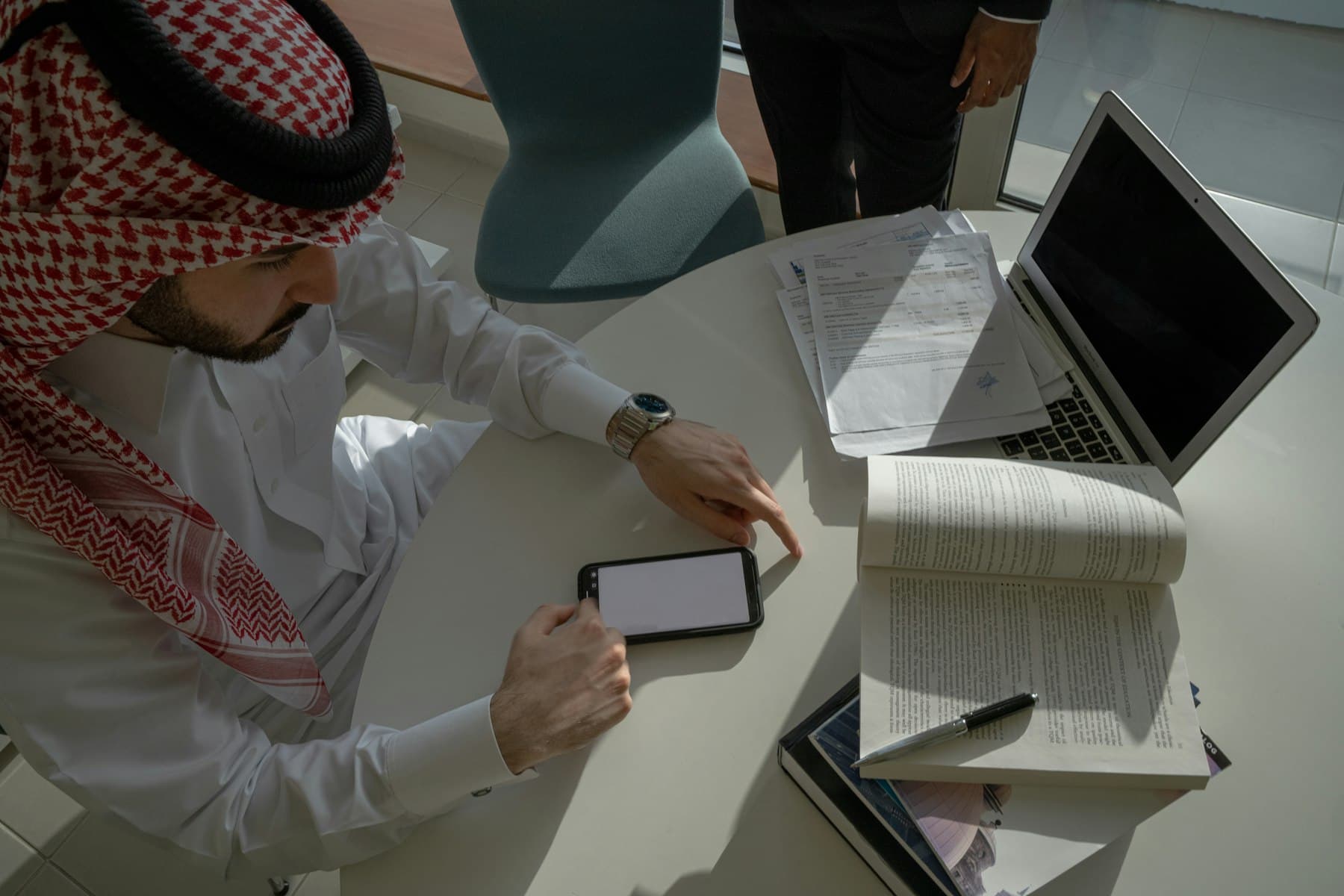 شخصان يرسمان خطة على لوحٍ أبيض في اجتماع عمل